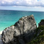 Tulum Ruins in Mexico A view of the ocean with beach and huge rock