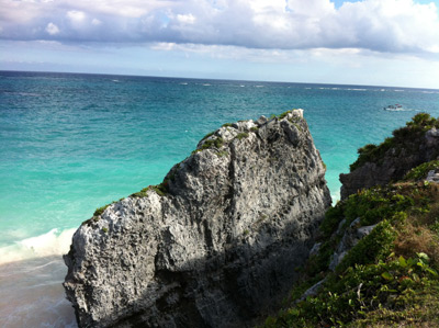 Tulum Ruins in Mexico A view of the ocean with beach and huge rock